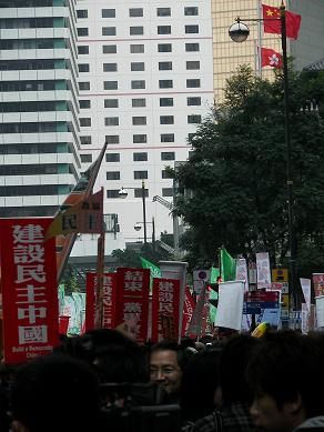 图六：游行出发前集会场所一景——在中华人民共和国国旗下打出“建设民主中国”、“结束一党专政”的标语。