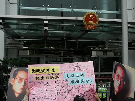 图六：送给刘晓波的生日卡，已被举起，即将飞入中联办大门内。