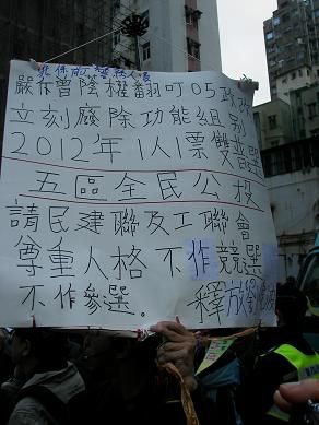 图十三：一个前警务人员也站了出来，举着自制的标语牌，要求“双普选”，呼吁“释放刘晓波”。