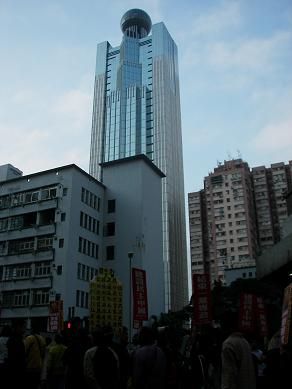 图十四：高举“结束一党专政”、“建设民主中国”示威标语的游行队伍正接近中联办大楼（即方圆球顶的大厦）。