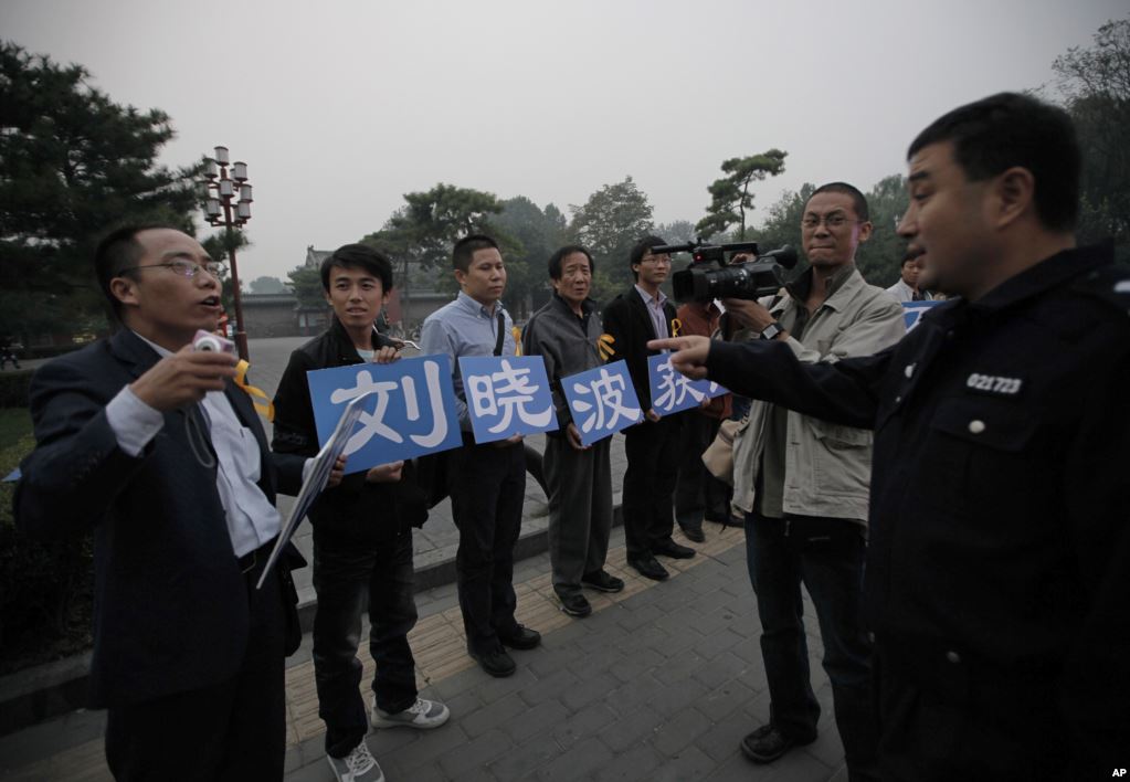 5 刘晓波的支持者在北京一个公园外面展示标语“庆祝刘晓波获诺奖”，警察和他们谈话（2010年10月8日）